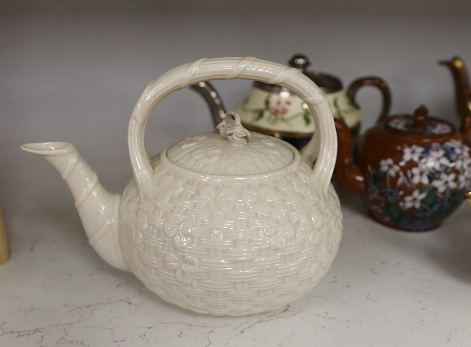 A quantity of various teapots including Belleek, Japanese Satsuma etc.